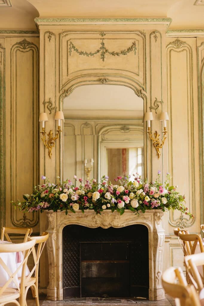 Grande décoration florale sur la cheminée du salon principal du château des Jardins de Bougainville