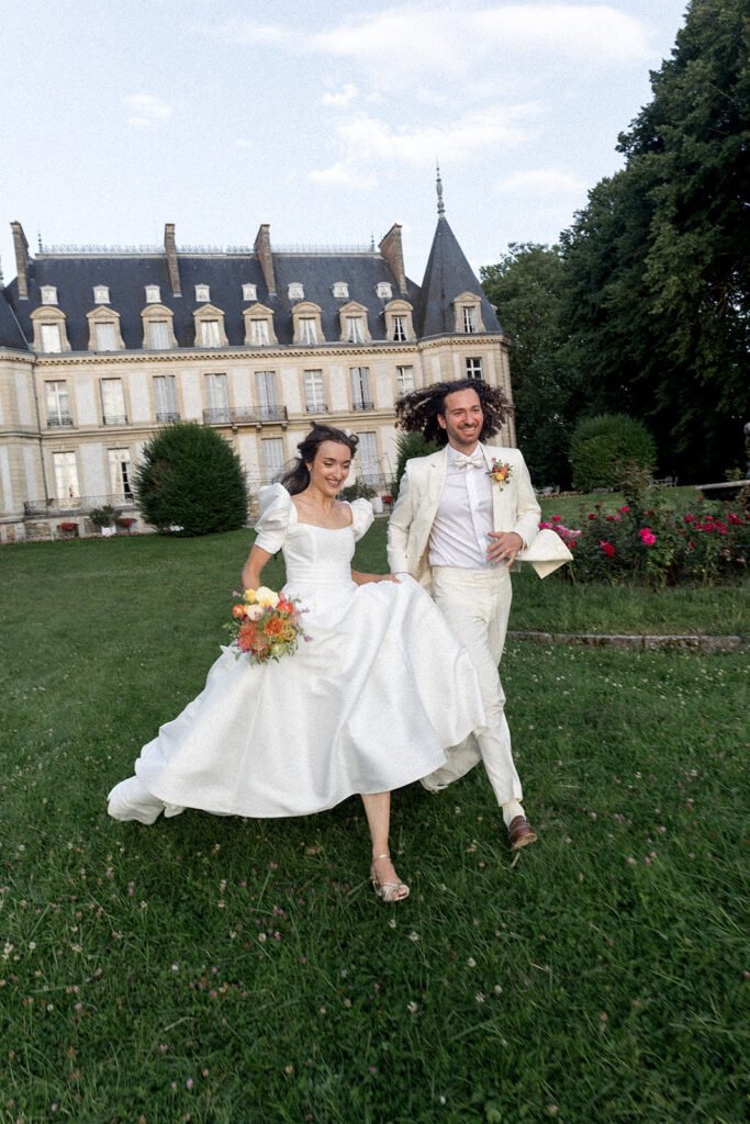 Les mariés courent dans les jardins du chateau de Santeny