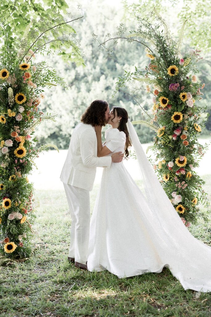 Arche de cérémonie dans les jardins du chateau de Santeny pour un mariage d'été dans un thème coloré